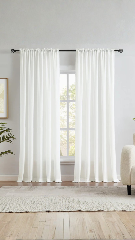 Sheer neutral curtains softly filtering natural light in a modern minimalist room.