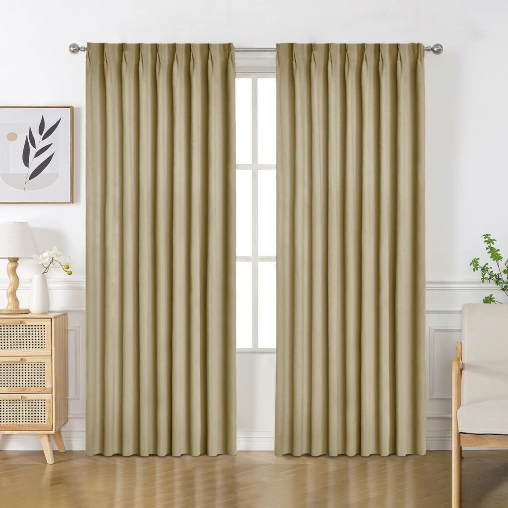 Beige room darkening curtains hanging in a light-toned bedroom.