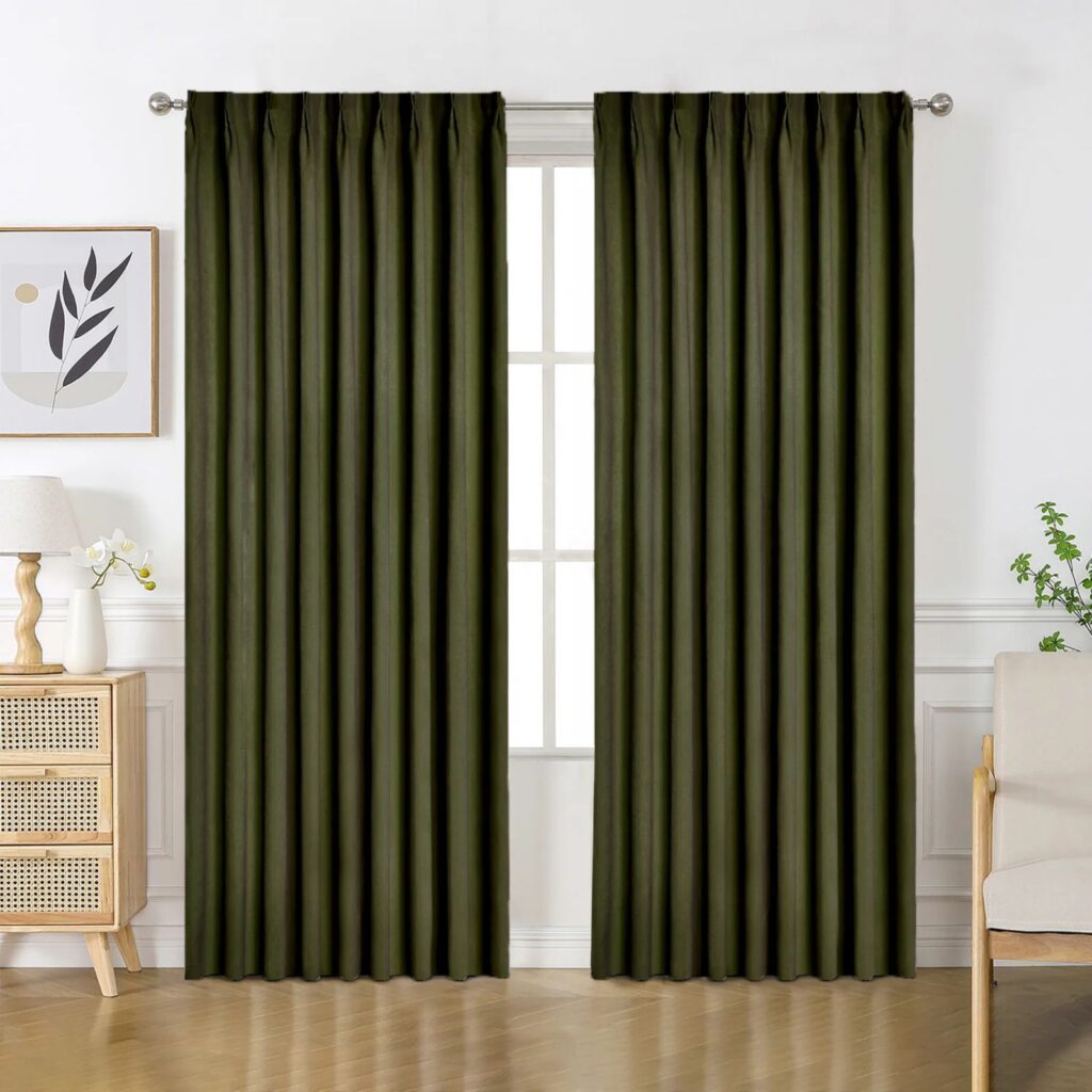 Dark green blackout curtains installed in a softly styled bedroom.