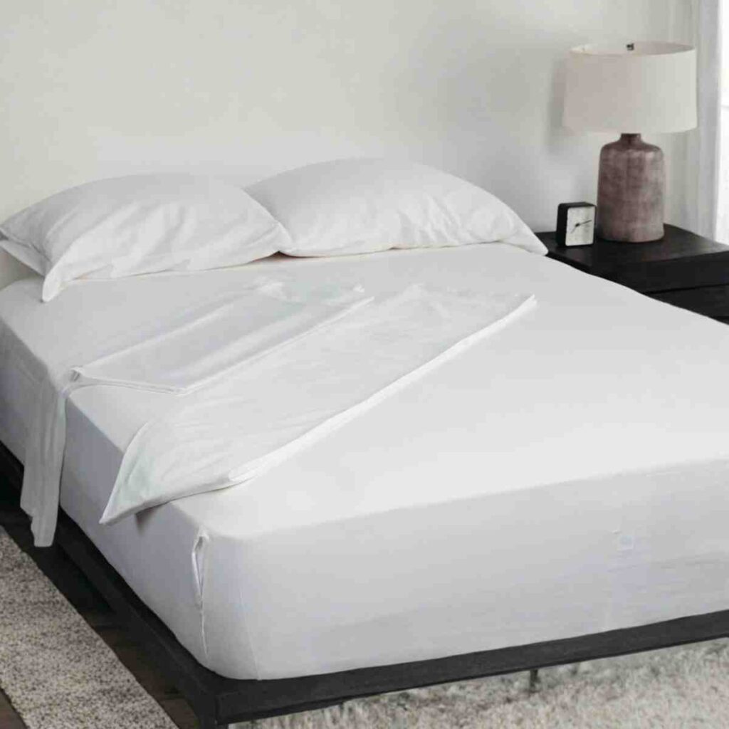 Premium white Bamboo sheets on an Airpedic mattress in a bright luxury bedroom, providing breathable comfort and quality.