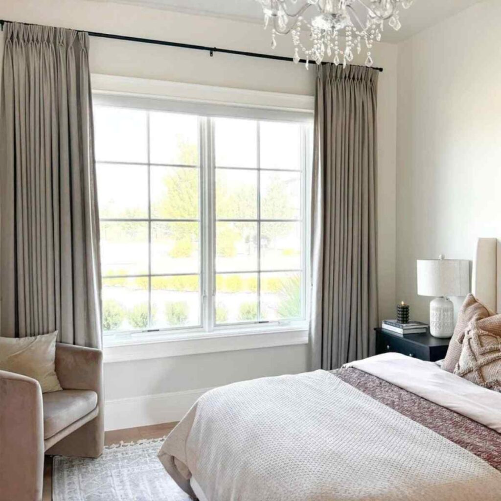 wLinen-textured custom blackout curtains in a neutral tone installed in a bright master bedroom for total light control.