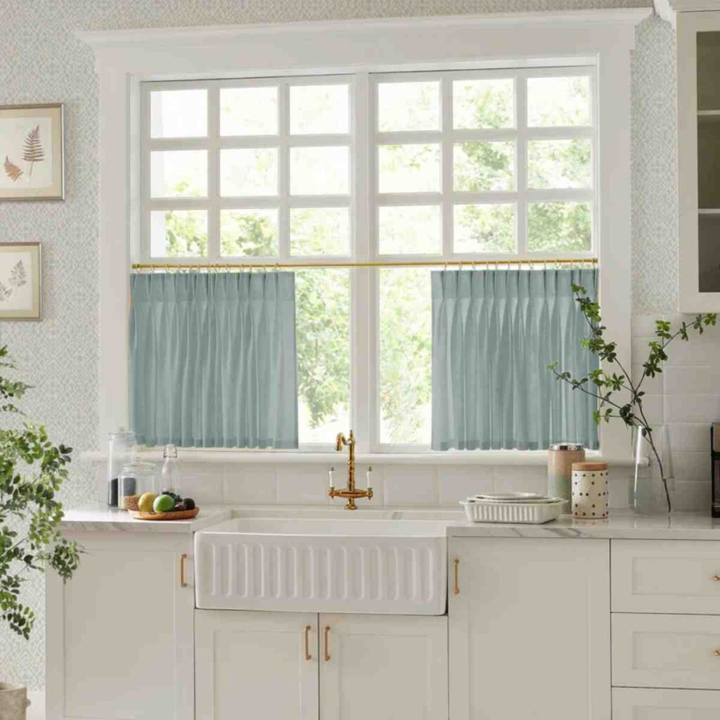 Light blue semi-sheer blackout curtains by CurtainUK in a bright, modern kitchen window.