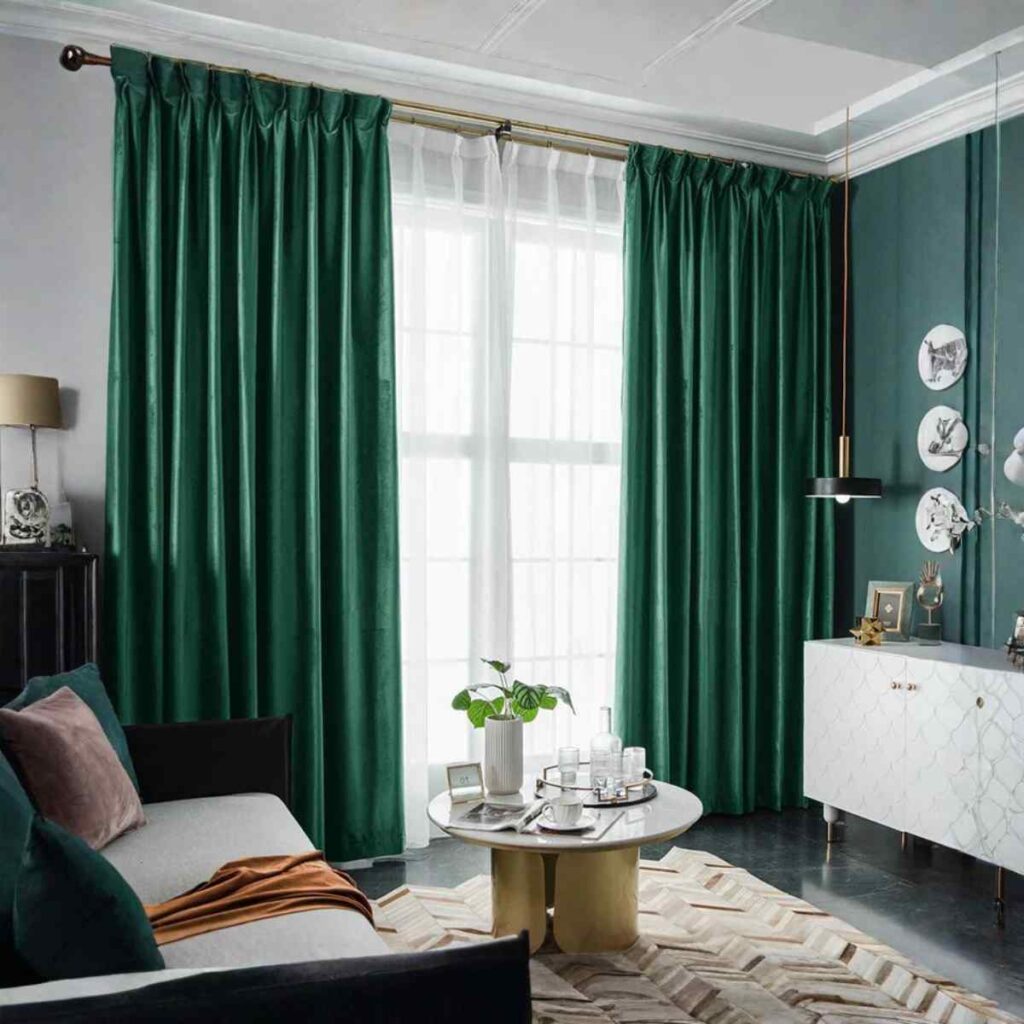 A modern living room featuring bold emerald green CurtainUK velvet-style curtains and a white fireplace.