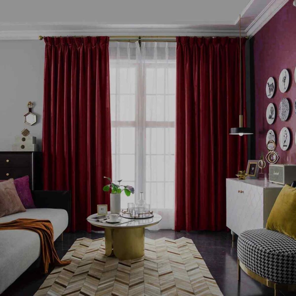 Elegant living room styled with rich ruby red velvet CurtainUK custom luxury drapery and a classic patterned rug.