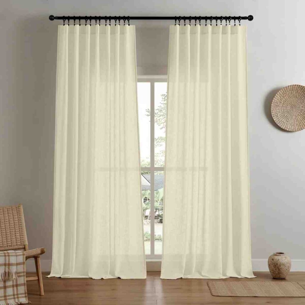Cream Joydeco light-filtering linen curtain draped elegantly in a warm-toned room.