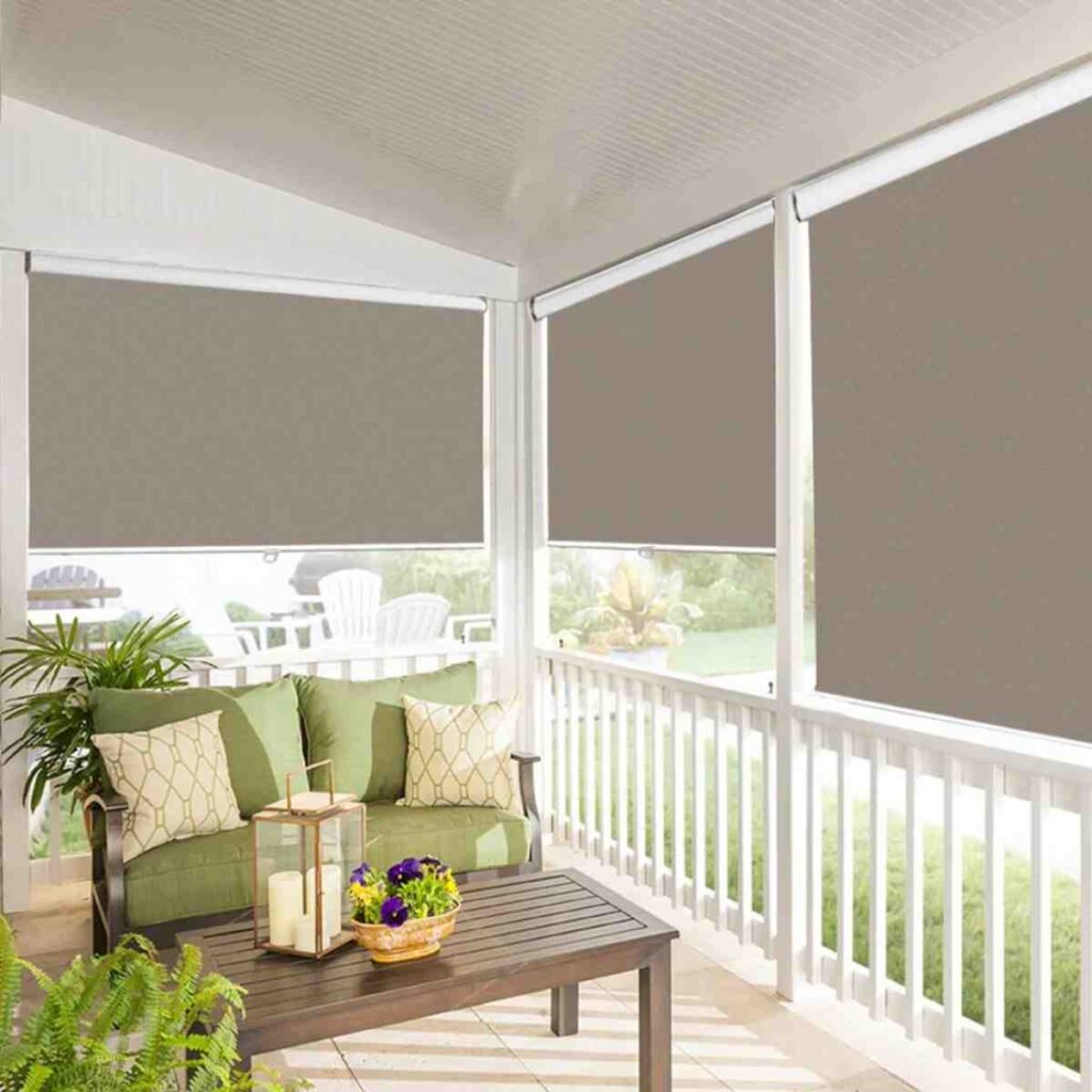 Multiple Joydeco 100% blackout roller shades in tan color installed on large patio windows.