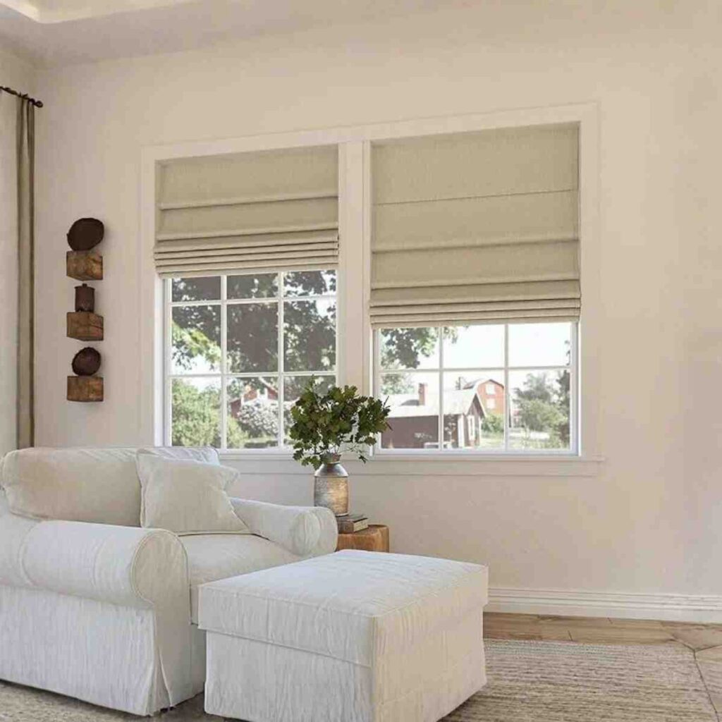 Joydeco essential blackout Roman shade in beige fabric installed in a cozy sitting area.