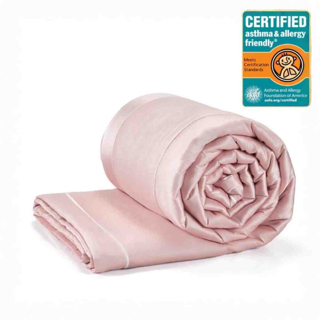 A rolled Promeed silk quilt in soft pink with a certified quality seal.