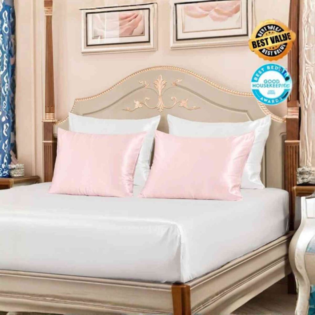 A beautifully styled bed with Promeed blush pink silk sheets and matching pillows in a bright, elegant bedroom.