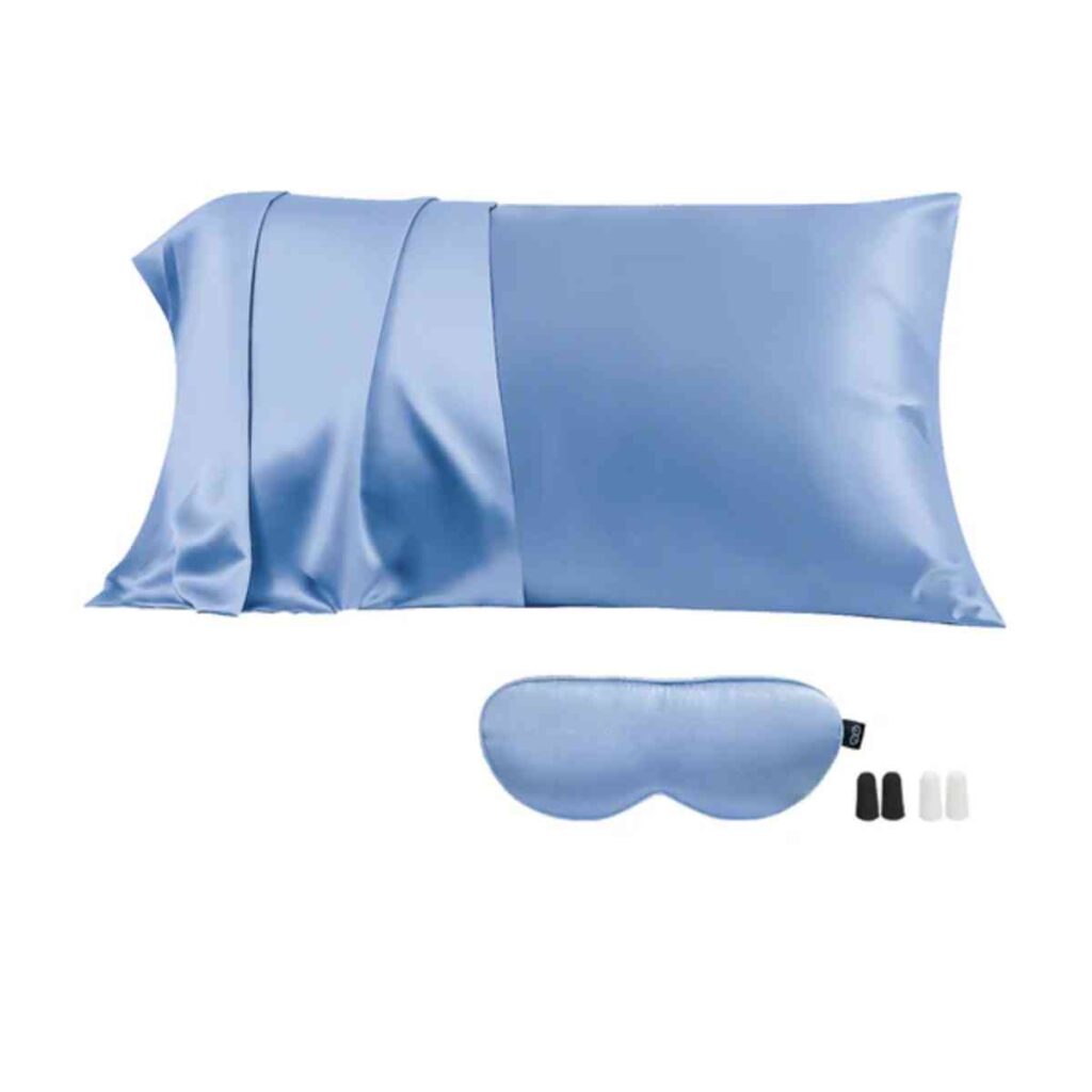 A luxurious light blue Promeed silk pillowcase paired with a matching silk eye mask, displayed on a plush white bed.