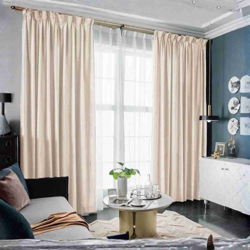 Modern beige velvet blackout curtains for soft neutral interiors Luxurious beige velvet blackout drapes featured as modern custom window treatments in a sophisticated living room with gold accents and a warm, minimalist aesthetic.