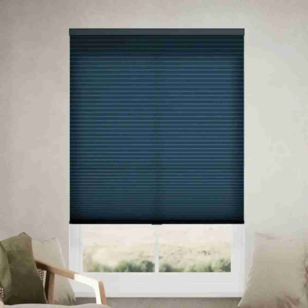Curtainuk Light Filtering Cellular Shades in Navy Blue for Modern Living Spaces 1 Sophisticated navy blue filtering cellular shades with a honeycomb texture installed on a window in a bright, modern living room.