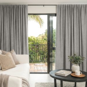 Joydeco tailored window treatment presentation highlighting premium alder light grey curtain setup over a clean living room setting.