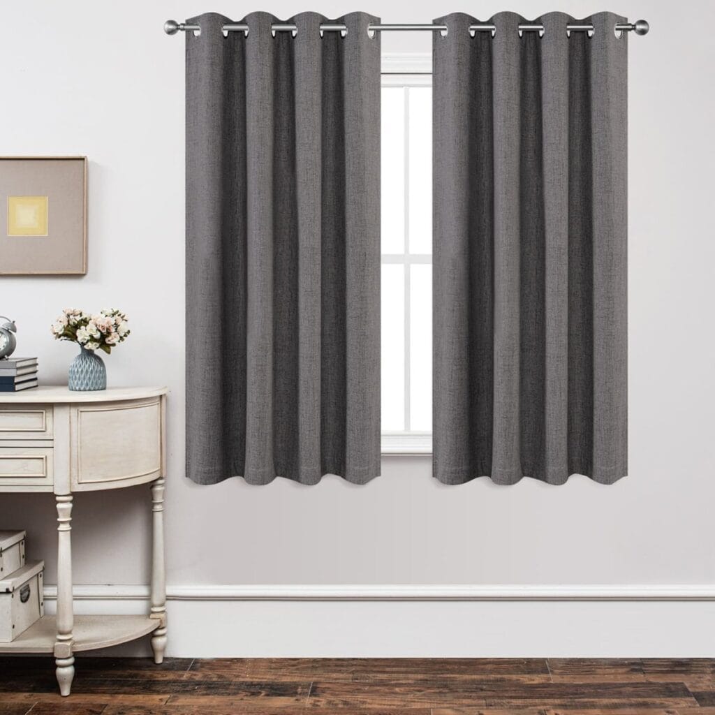 Beautifully styled linen curtains grey faux hanging gracefully on a black metal curtain rod.