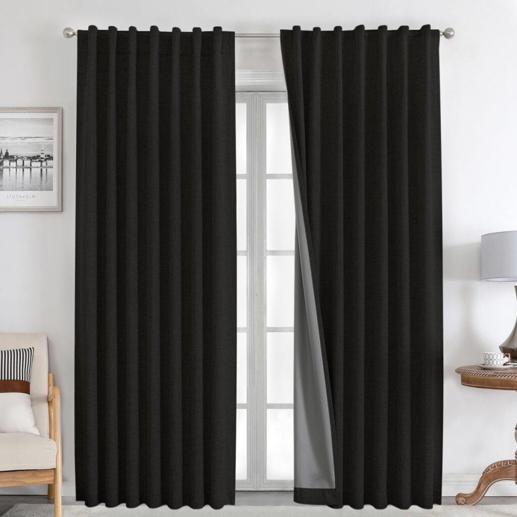 Clean interior visual presentation showing how black natural linen curtains seamlessly dress a living room layout.