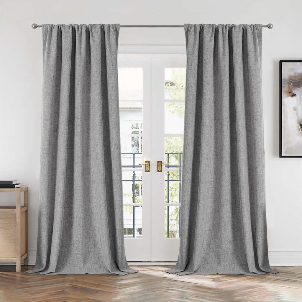 Elegant drapery style exhibition accenting the heavy texture of light grey blackout curtains near a cozy corner.