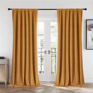 Detailed macro view highlighting the rich textile texture of clean mustard yellow velvet curtains hung in a contemporary bedroom.