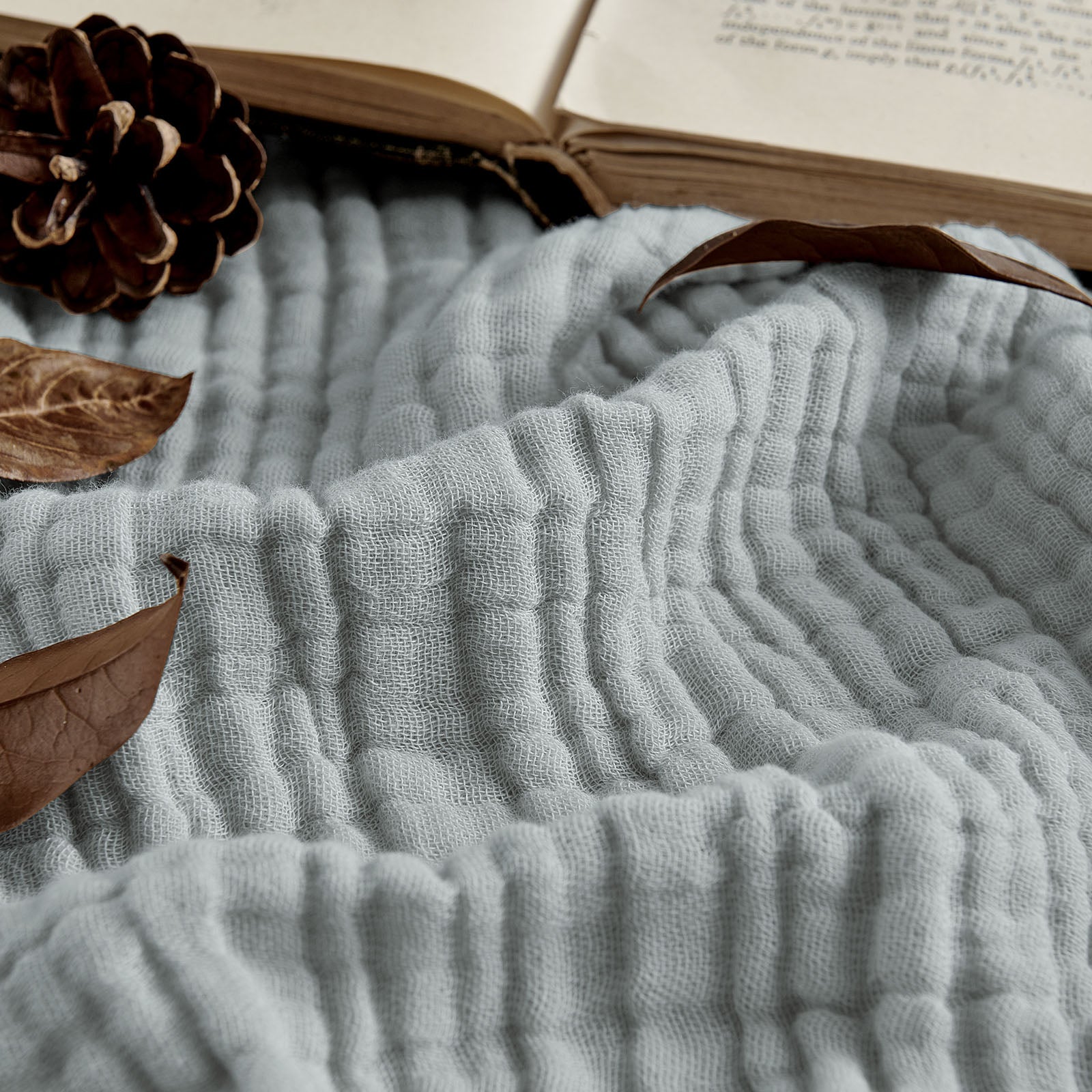 Joydeco 100% Cotton Muslin 4-Layer Breathable Throw Blanket - Grey 1 Close-up macro shot accenting the intricate weave and soft tactile surface detailing of a durable breathable throw blanket grey.