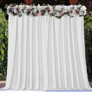 Sleek architectural setup showcasing how a set of functional white backdrop curtains separates spaces and prevents outside drafts.