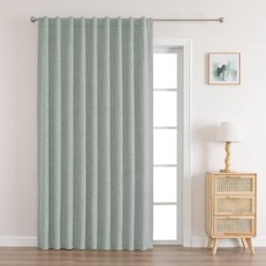 A modern well-lit home interior showing functional sage green door curtains mounted clean over a residential glass window frame.