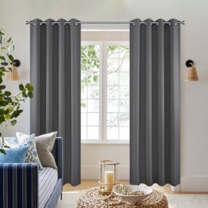 Pair of joydeco blackout light grey thermal insulated long drapes by Joydeco hanging in a bright modern bedroom.