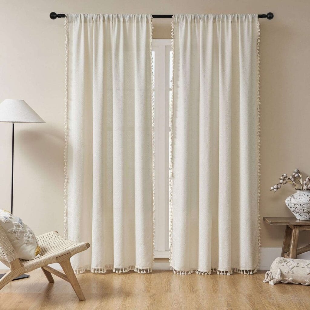 Bright contemporary window frame accenting the beautiful design of beige boho linen curtains letting in soft natural light.
