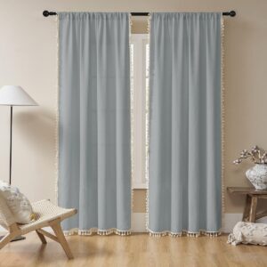 A modern well-lit home interior showing functional stone blue boho curtains mounted clean over a residential glass window frame.