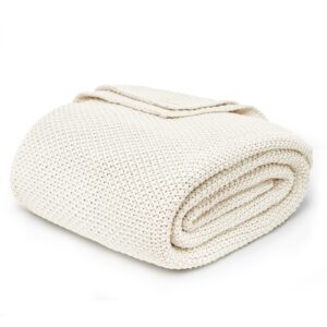 Joydeco soft textiles showcase featuring a premium quality cozy knit blanket cream white loosely folded over a contemporary sofa frame.