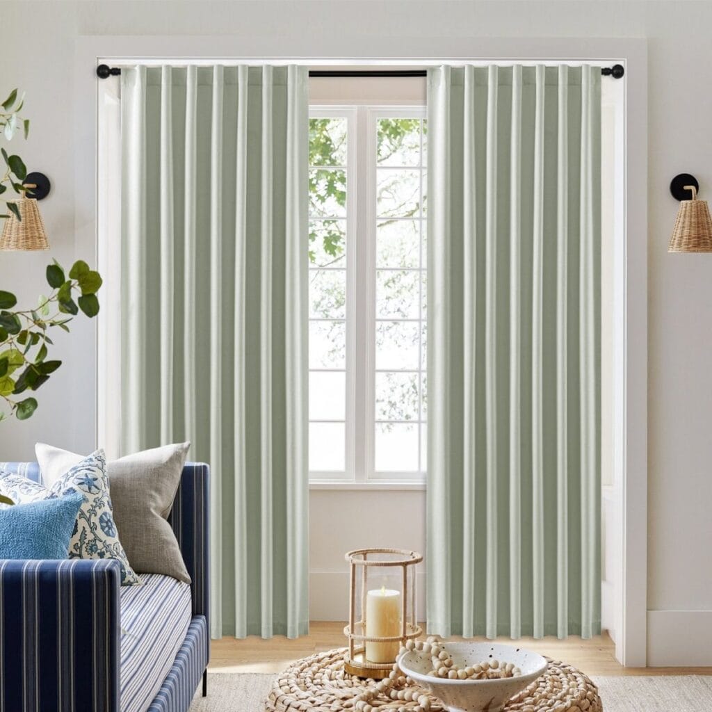 Nicely styled home layout focusing on the clean horizontal folds of a custom-hung sage green curtains back tab drape set.
