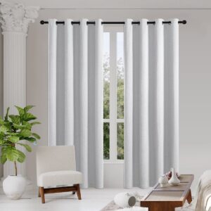 A bright living room space displaying elegant thermal curtains off white hanging beautifully by a modern window layout.