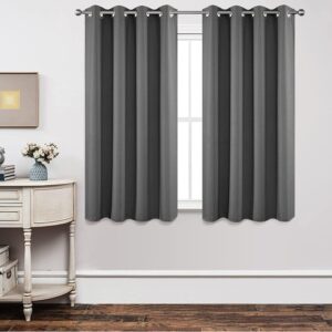 A polished residential bedroom layout featuring a beautiful blackout light grey curtain drawn shut to secure total rest.