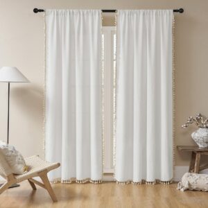 A bright living space window adorned with a gorgeous white boho curtain filtering daylight beautifully.