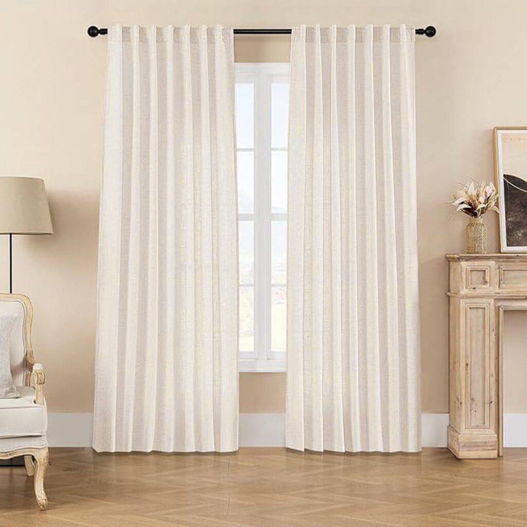 Sleek contemporary living room arrangement showcasing how a set of integrated off white linen curtain dresses up the window space.