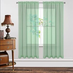 A bright living space window adorned with a gorgeous mint green sheer curtain filtering daylight beautifully.