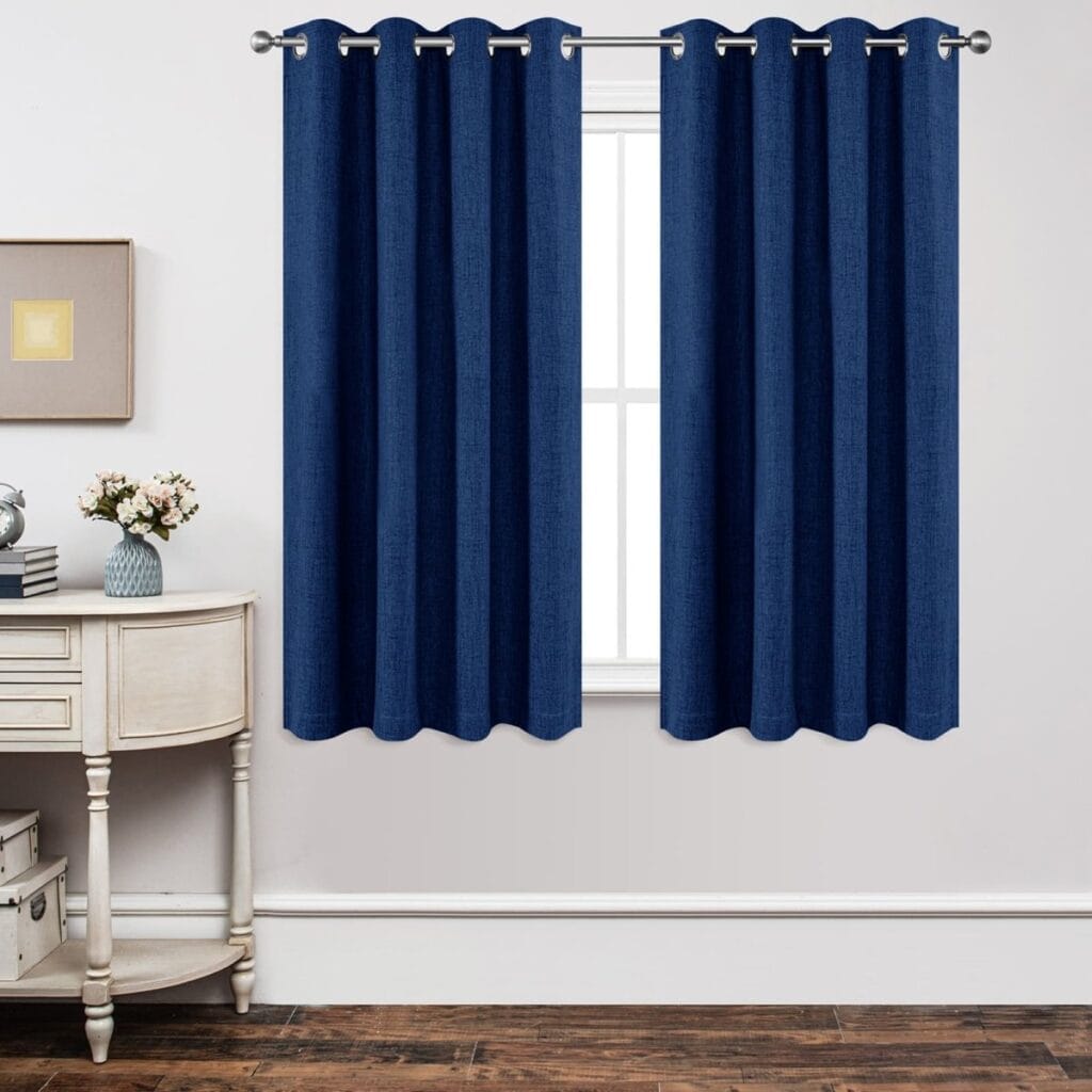 Nicely dressed home office layout focusing on the subtle weave pattern of a tailored royal blue thermal curtain.