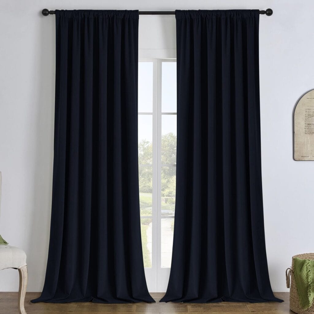 Joydeco functional home visual emphasizing an elegant velvet blackout curtain black hanging gracefully over a minimalist setting.