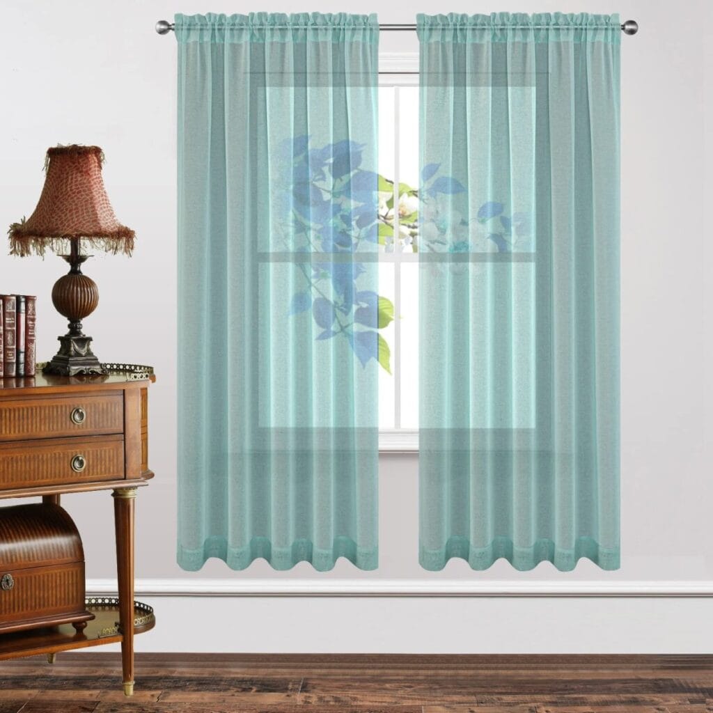 Bright contemporary window frame accenting the beautiful design of teal blue sheer curtains letting in soft natural light.