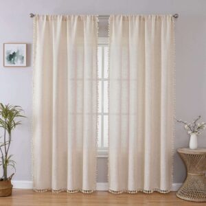 A perfectly styled layout showing beige boho tassel curtains hanging by a window in a contemporary interior.