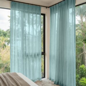 A modern well-lit living area featuring an elegant linen sheer curtain stone blue filtering daylight beautifully.