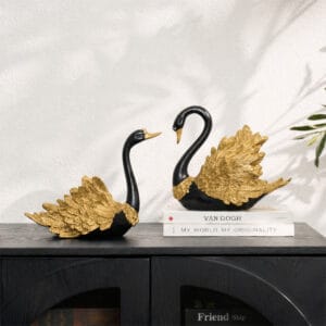 Stylish black gold swan figurines with sleek bodies and elegant gold-painted wings.