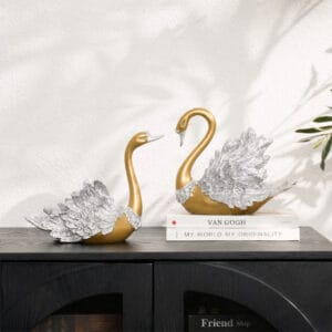 Graceful 2-piece resin décor set featuring elegant gold swan figurines with detailed wings.