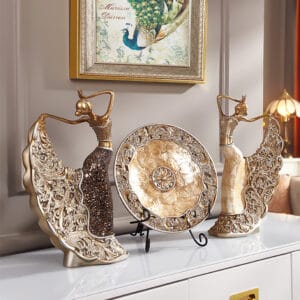 Elegant gold-finished decorative dancer figurines accented with shell and glass elements.