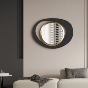 Sculptural matte black iron frame surrounds a gold-finished abstract wall mirror.