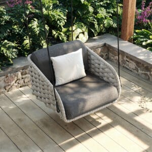 Relaxing on the Cocaro Outdoor Swing Chair with plush dark gray cushions and light gray frame.