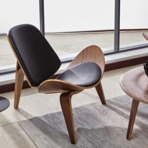 Stylish walnut tripod lounge chair featuring a faux leather seat and FSC-certified frame.