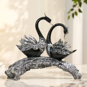 Elegant black and silver swan couple sculpture on a textured tree stump-inspired base.